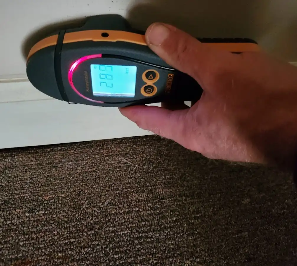 Moisture detection at baseboard during Storm Damage Restoration in Justin